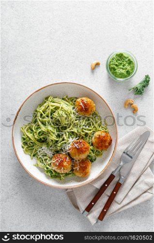 Chicken meatballs with spaghetti and green kale cashew pesto sauce. Top view