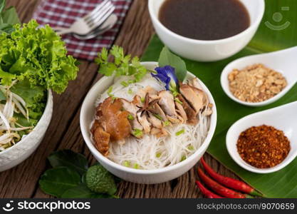 Chicken noodle in a bowl with side dishes, Thai food. Selective focus