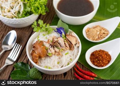 Chicken noodle in a bowl with side dishes, Thai food. Selective focus
