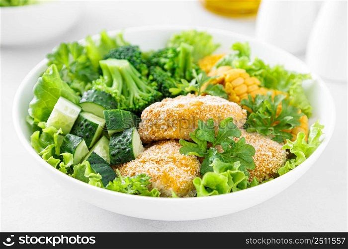 Chicken nuggets with broccoli, corn, cucumbers and salad lettuce