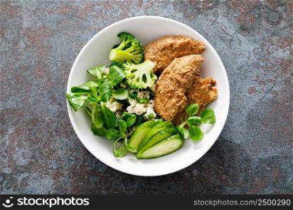Chicken nuggets with fresh corn salad, broccoli, cucumber and rice, top view