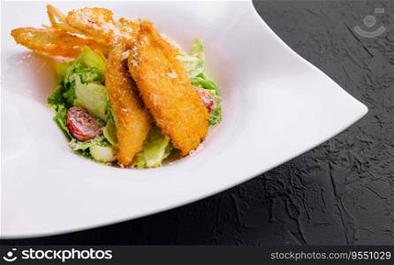 Chicken nuggets with vegetables salad on plate