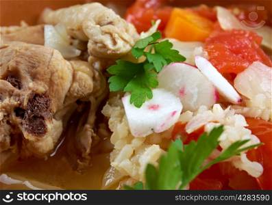 chicken posole garnished with carrots, tomato and radish.