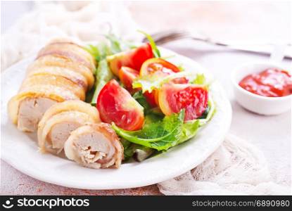 chicken roll with salad on the white plate