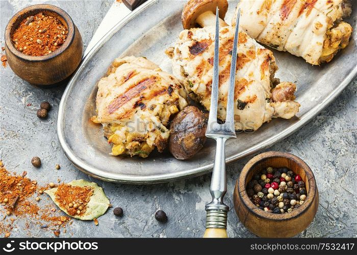 Chicken rolls stuffed with wild mushrooms on a metal stylish dish. Chicken roll with mushrooms