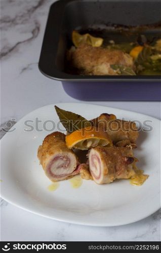 chicken rolls with smoked scamorza cheese and cooked ham and passed in breadcrumbs. Baked with bay leaf and lemon slices
