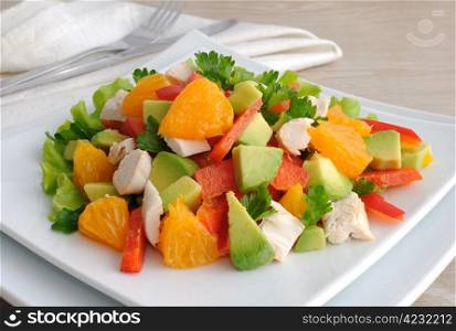chicken salad with avocado, sweet peppers and oranges closeup