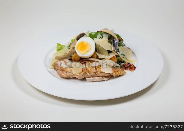 Chicken Salad with egg and cheese on a white plate on a white background