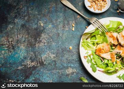 Chicken salad with pine nuts on rustic background, top view, place for text