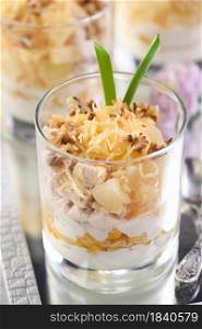 Chicken salad with pineapple, corn, seasoned with Greek yogurt, crushed nuts and grated cheese. A salad in a glass, a great idea for serving food in portions.