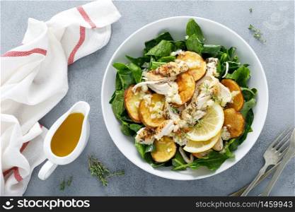 Chicken salad with spinach and crispy potatoes dressed with olive oil, garlic, lemon, onion and thyme