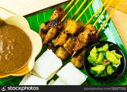 Chicken satay with cubic rice, atjar and curry bean sauce. Tradition food in Thailand