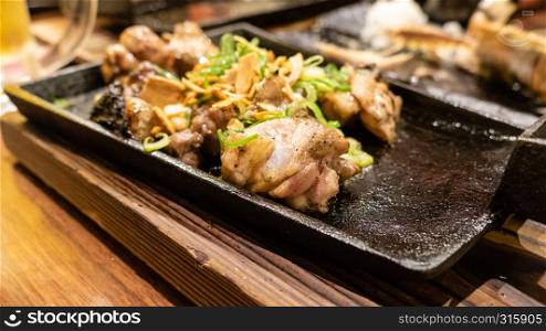 Chicken served while grilling on metal dish at Japanese izakaya style restaurant