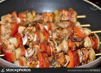 Chicken skewer with vegetables. Frying in a pan.