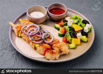 chicken skewers with greek salad and creamy, spicy sauces