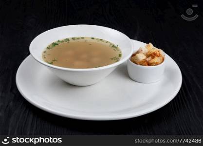Chicken soup bouillon in a plate with chicken meatballs and croutons. Chicken soup chicken meatballs