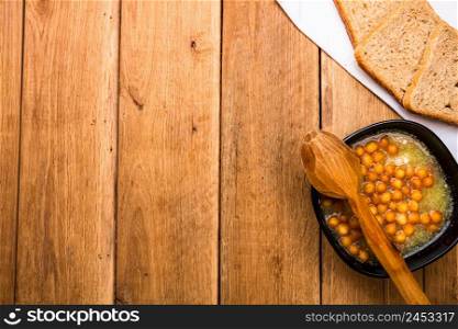 Chicken soup with sour cream, wholegrain toast on white napkin and croutons for lunch over wooden table, top view, copy space, lunch concept