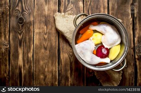 Chicken soup with vegetables. On a wooden table.. Chicken soup with vegetables.