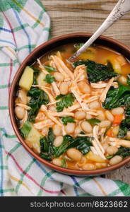 Chicken soup with white beans, spinach and tomato