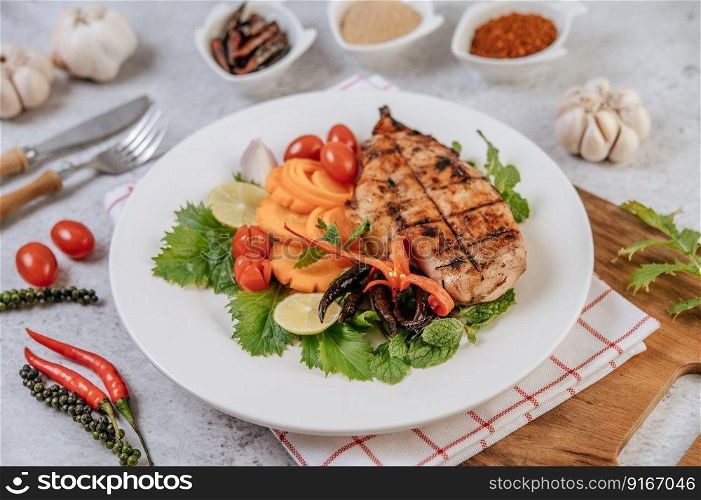 Chicken Steak with Lemon, Tomato, Chili, and Carrot on White Plate.