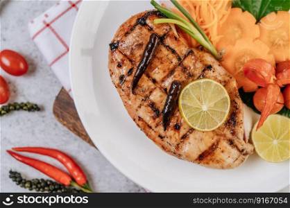 Chicken Steak with Lemon, Tomato, Chili, and Carrot on White Plate.