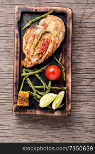 Chicken steak with roasted vegetable on wooden cutting board.Festive dinner.Healthy food.. Whole chicken breast
