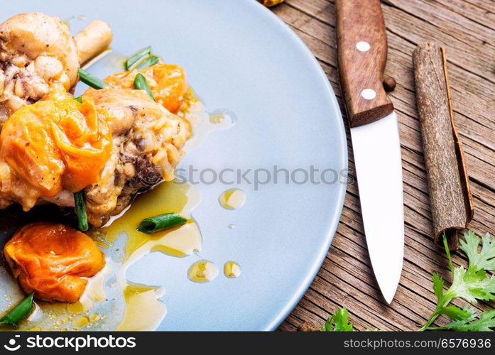 Chicken stewed in apricot sauce. Summer meat dish. Chicken stewed in apricots