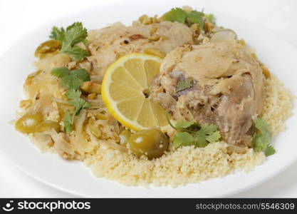 Chicken thighs cooked with olives, onions and orange and lemon juice, served over a bed of couscous and garnished with coriander (cilantro) leaves