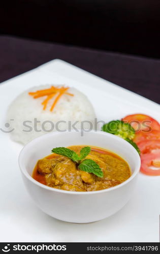 chicken tikka masala served with rice and vegetables. chicken tikka masala