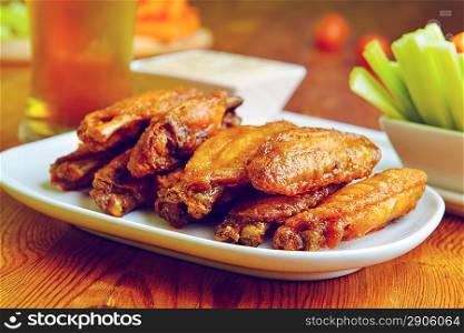 chicken wings with celery, carrot and glass of beer