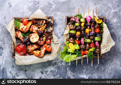 Chicken wings with crispy crust. Barbecue chicken wings on wooden tray and grilled vegetables.BBQ.American food