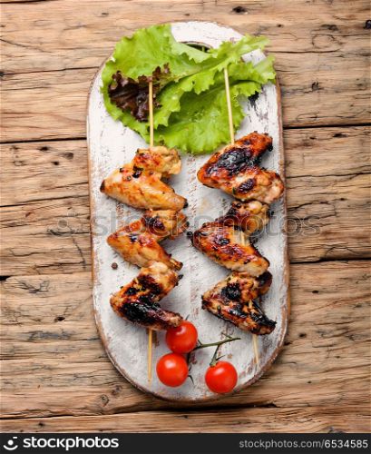Chicken wings with crispy crust. Chicken wings on barbecue grill,cooked on skewers.BBQ