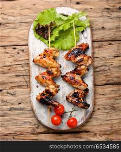 Chicken wings with crispy crust. Chicken wings on barbecue grill,cooked on skewers.BBQ