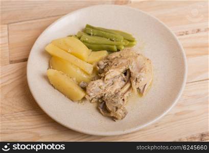 chicken with potatoes and vegetables on a white plate. top view