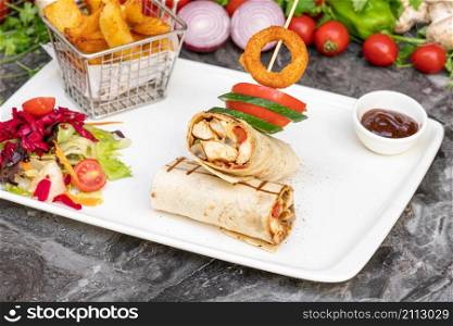 Chicken wrap with french fries and salad on marble table