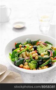 Chickpea and spinach vegan vegetable salad with broccoli, sweet pepper, olives and grilled zucchini. Mediterranean diet, healthy food