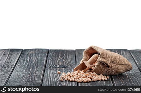 Chickpea spill out of the bag and wooden scoop on table isolated on white background. Chickpea spill out of bag and scoop