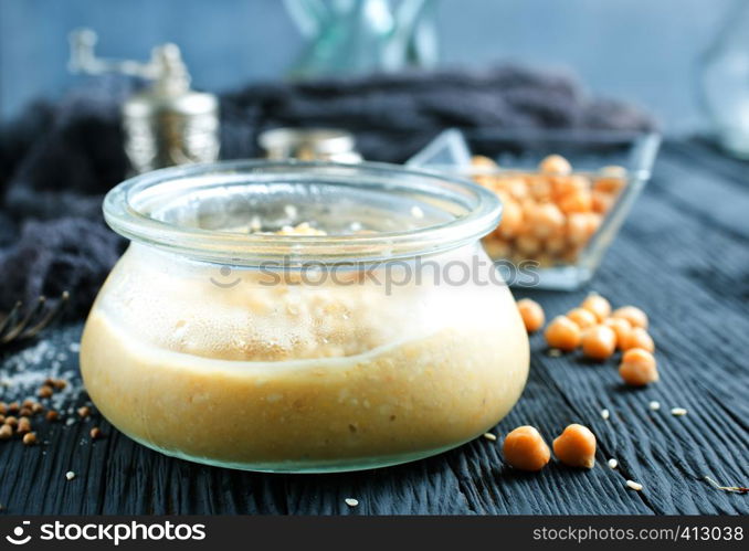 Chickpea spread or hummus with sesame seeds in glass bowl