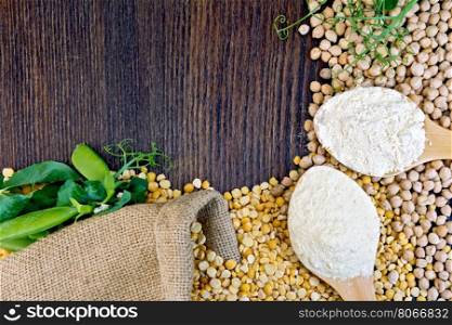 Chickpeas and chickpea flour in a spoon, green pods on burlap background on wooden board