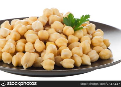 Chickpeas in a brown plate, isolated over white background.