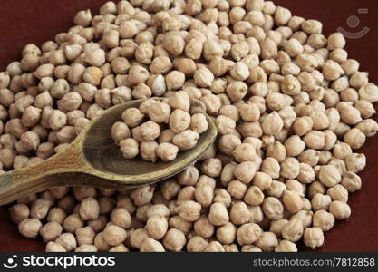 Chickpeas in old ceramic plate with wooden spoon