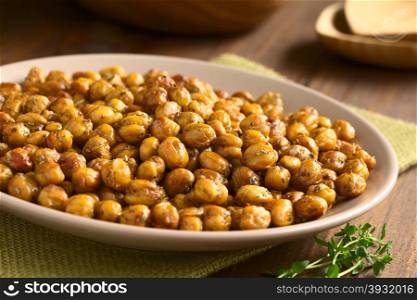 Chickpeas roasted with thyme, oregano, salt and pepper, photographed with natural light (Selective Focus, Focus in the middle of the chickpeas)