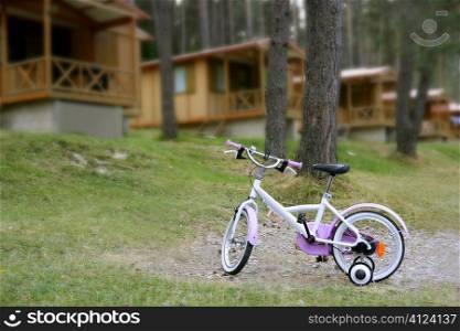 Chidren pink bicycle in wooden cabin mountain pine camping Pyrenees