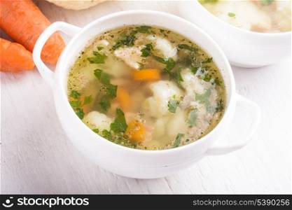 Chiken cauliflower and carrot soup in a white cup