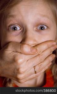 child abuse - the adult closes the child's mouth with his hand