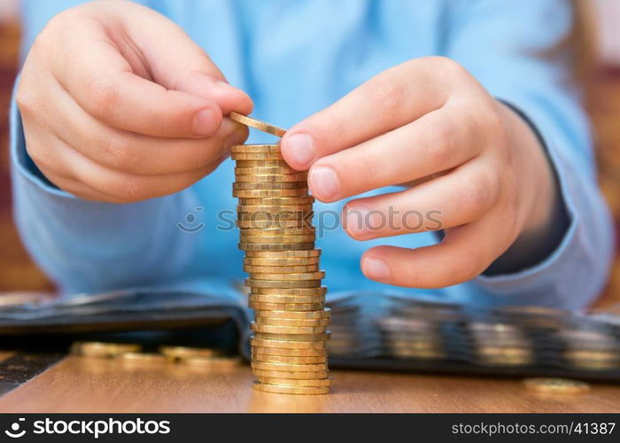 Child amassed a large pile of gold coins, close-up