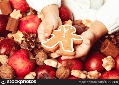 Child&amp;#39;s hands hold a red apple and gingerman cookie