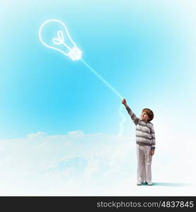 Child and bulb. Image of little boy against cloud background. Idea concept