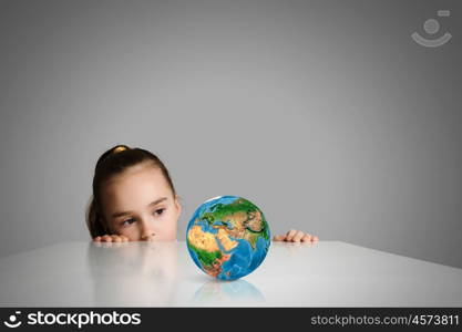 Child and Earth planet. Little cute girl looking at globe. Elements of this image are furnished by NASA