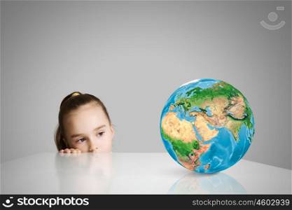 Child and Earth planet. Little cute girl looking at globe. Elements of this image are furnished by NASA